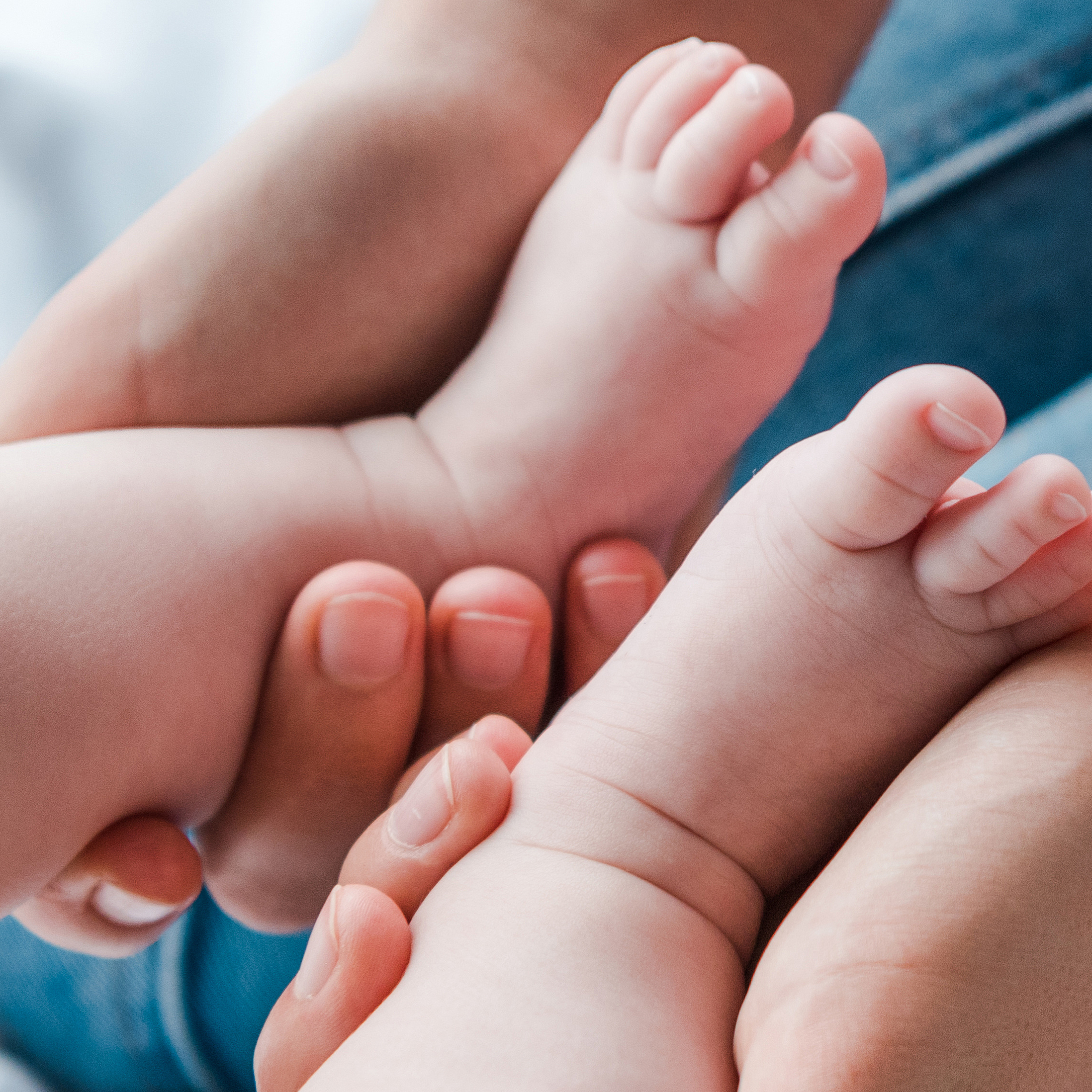 Physiotherapeutin hält zwei Babyfüsse