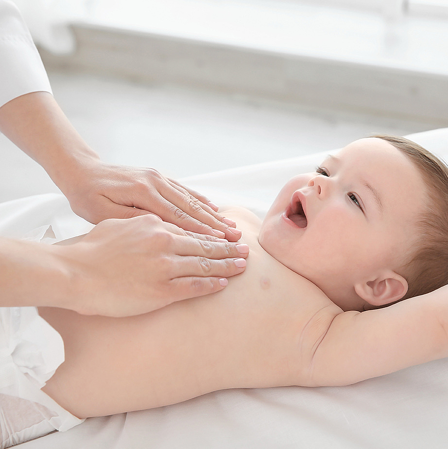 Baby auf dem Rücken liegend – Hände der Therapeutin auf der Brust